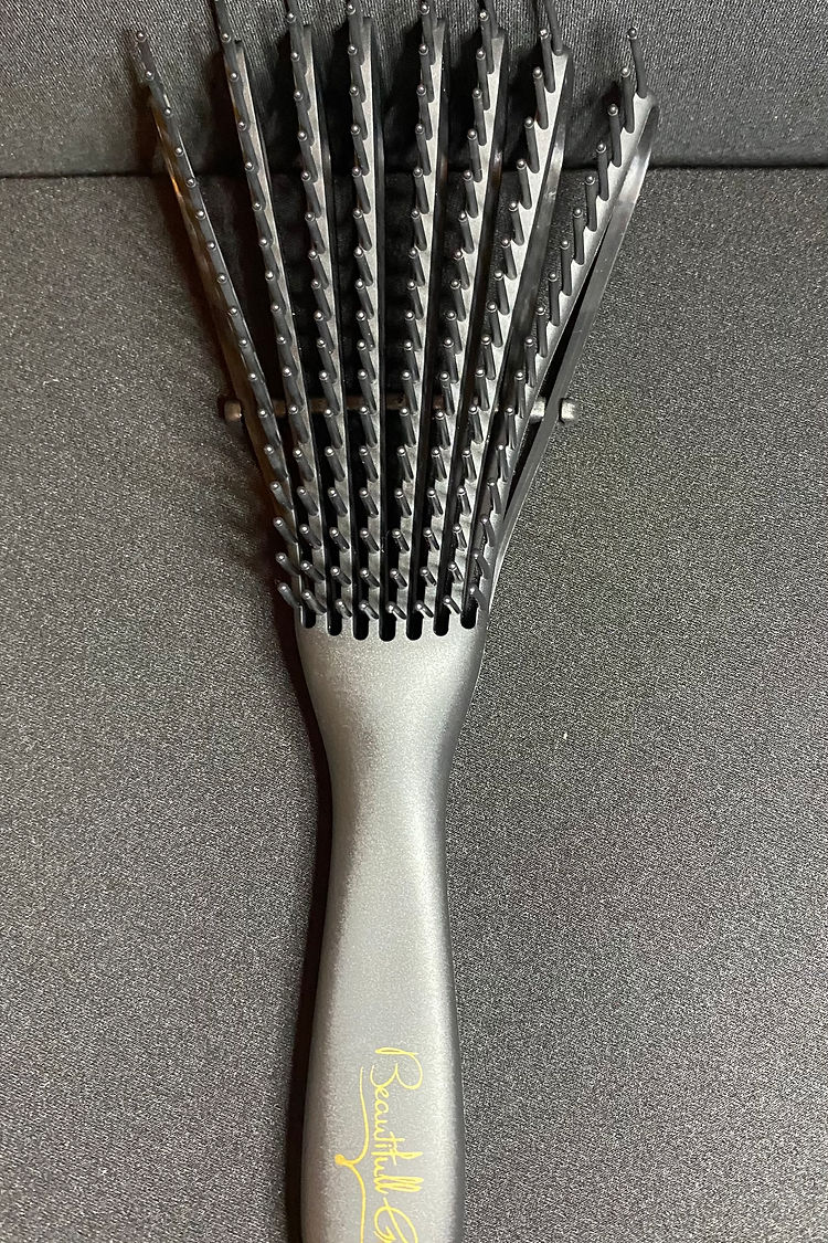 Metallic hairbrush with textured bristles on a gray background