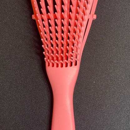 Pink hairbrush on a black background