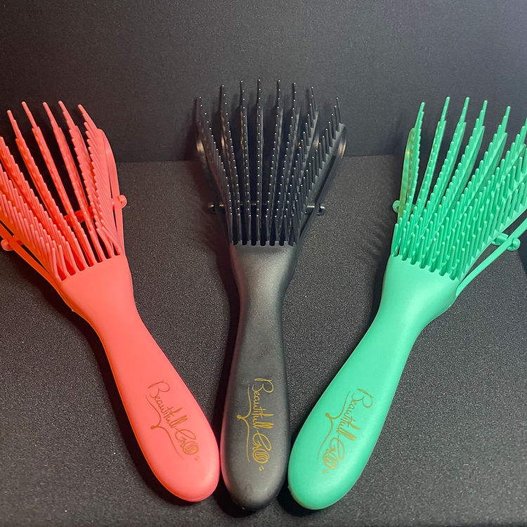 Three hairbrushes in red, black, and green on a dark background