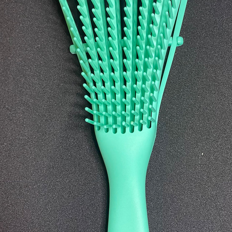 Green hairbrush on a dark gray background